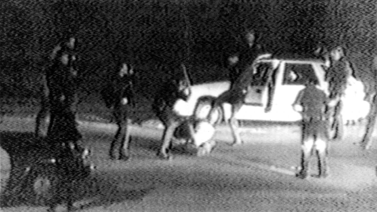 Grobkörnige Schwarz-Weiß-Aufnahme: Polizisten schlagen und treten auf e...</p>

                        <a href=