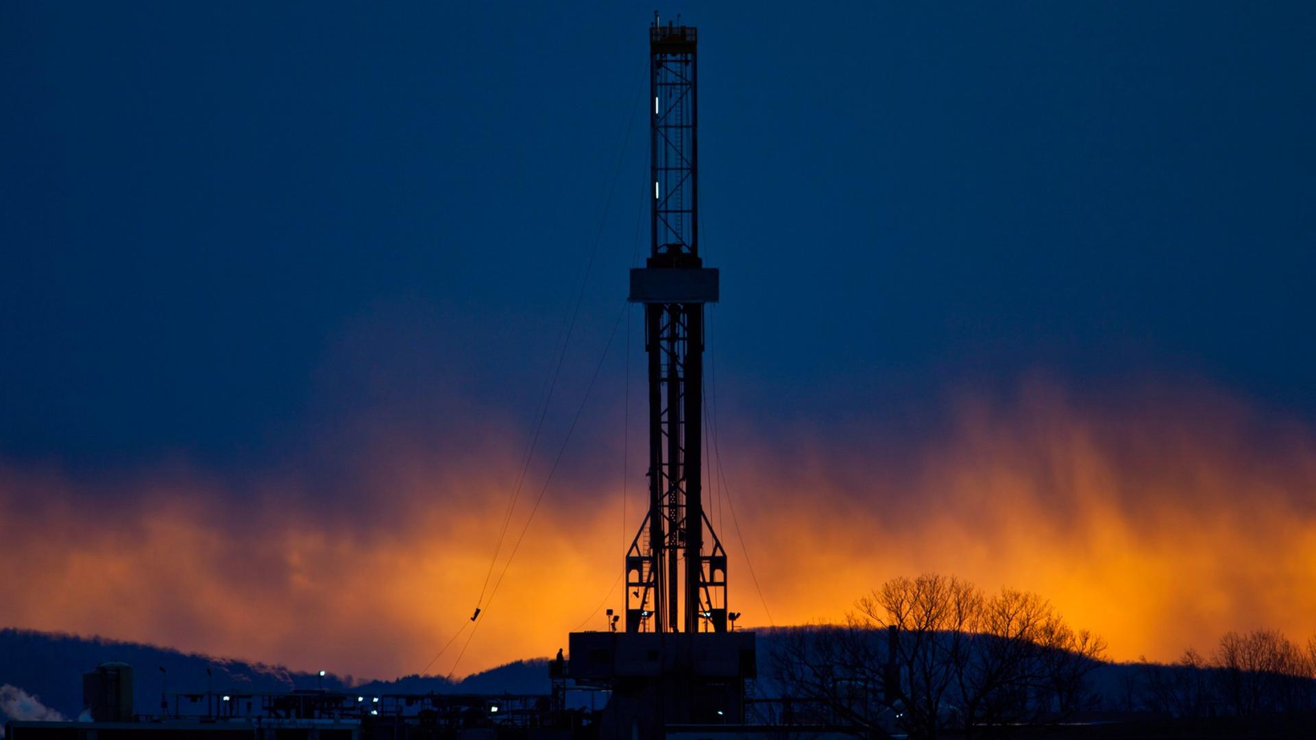Ein Fracking-Bohrturm in der Abenddämmerung.