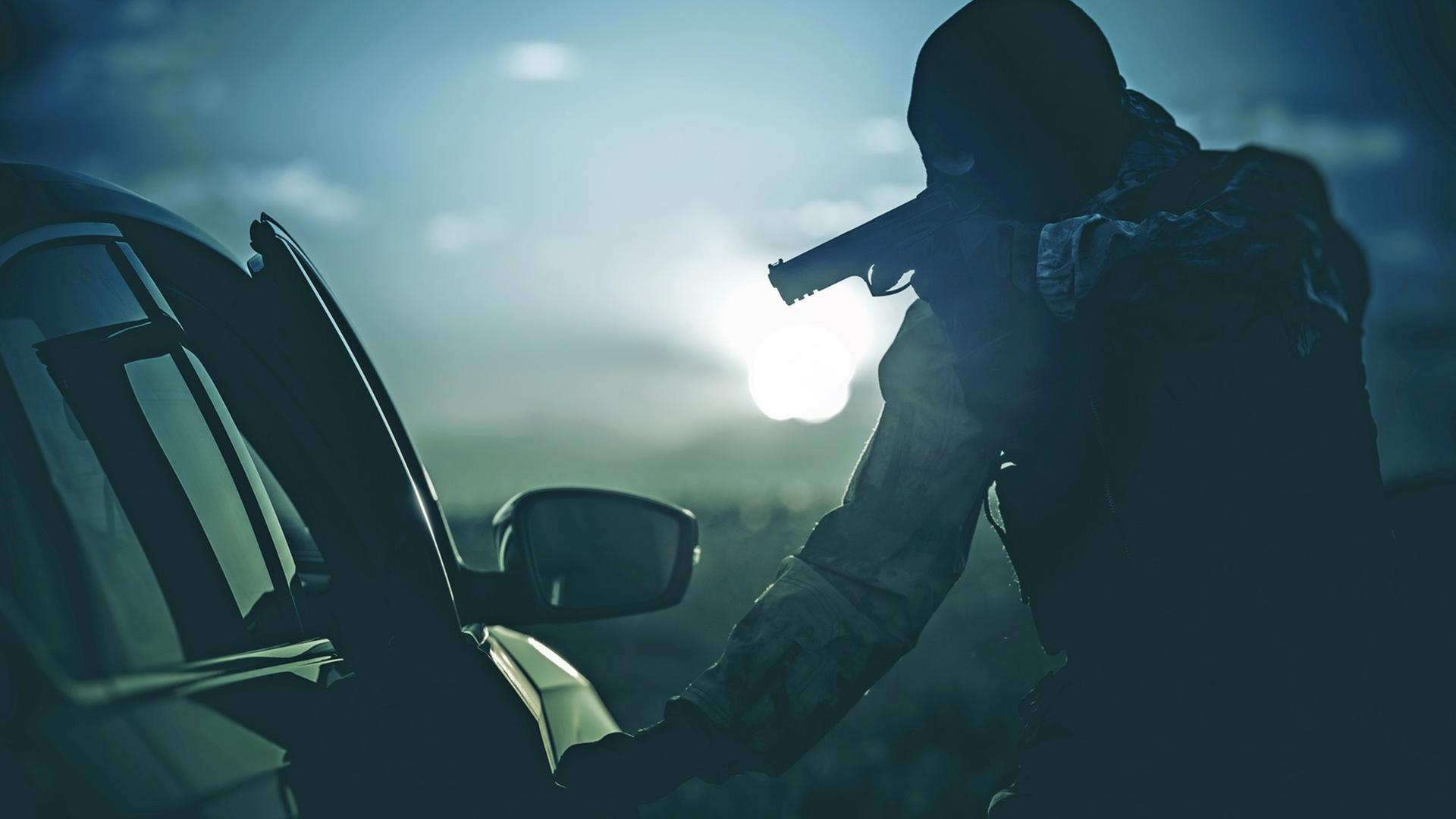 Eine Person mit Maske und Revolver öffnet in der Dunkelheit eine Autotür Eine Person mit Maske und Revolver öffnet in der Dunkelheit eine Autotür