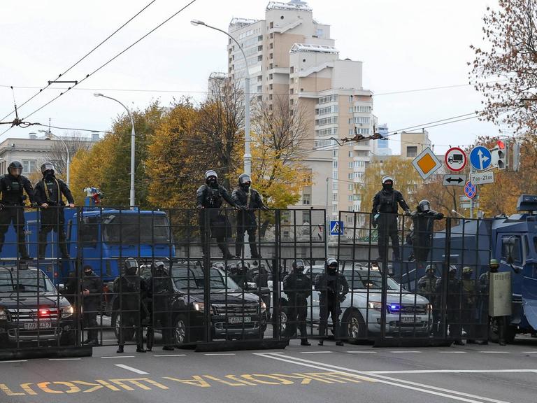 Polizisten haben auf einer Straße in Minsk eine Barrikade errichtet.