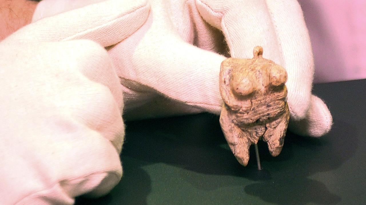 Die "Venus vom Hohlen Fels" liegt in der behandschuhten Hand eines Archäologen.