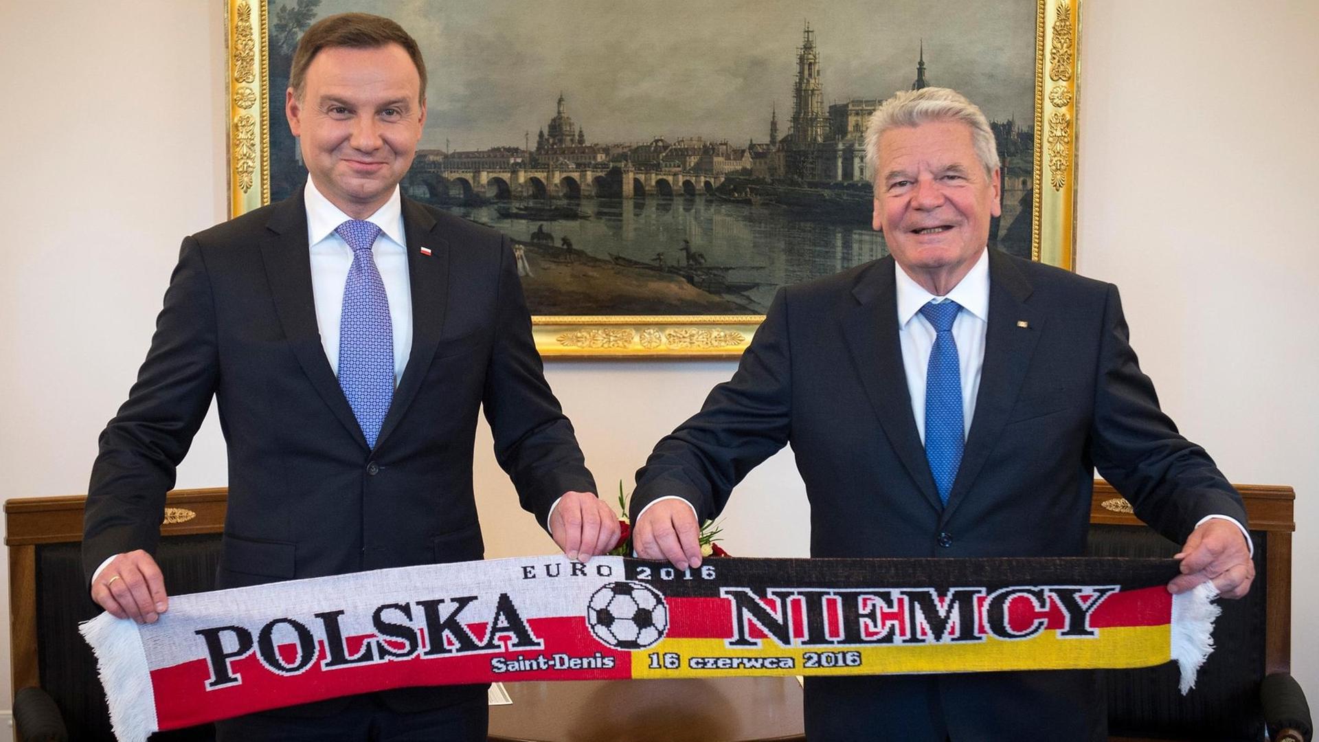 Bundespräsident Joachim Gauck (r) und sein Amtskollegen, der polnische Staatspräsident Andrzej Duda, halten am 16.06.2016 während des Antrittsbesuch des polnischen Staatspräsidenten in Schloss Bellevue anlässlich des Gruppenspiels der Fußball Europameisterschaft 2016 zwischen Deutschland und Polen einen Schal in den Händen. Bundespräsident Joachim Gauck (r) und sein Amtskollegen, der polnische Staatspräsident Andrzej Duda, halten am 16.06.2016 während des Antrittsbesuch des polnischen Staatspräsidenten in Schloss Bellevue anlässlich des Gruppenspiels der Fußball Europameisterschaft 2016 zwischen Deutschland und Polen einen Schal in den Händen.