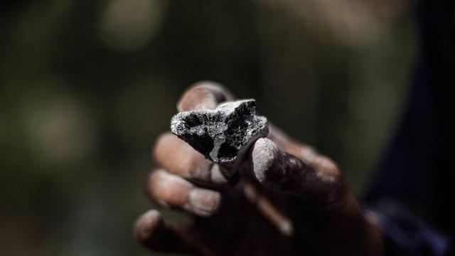 Ein Stück Kohle in der Hand eines Grubenarbeiters