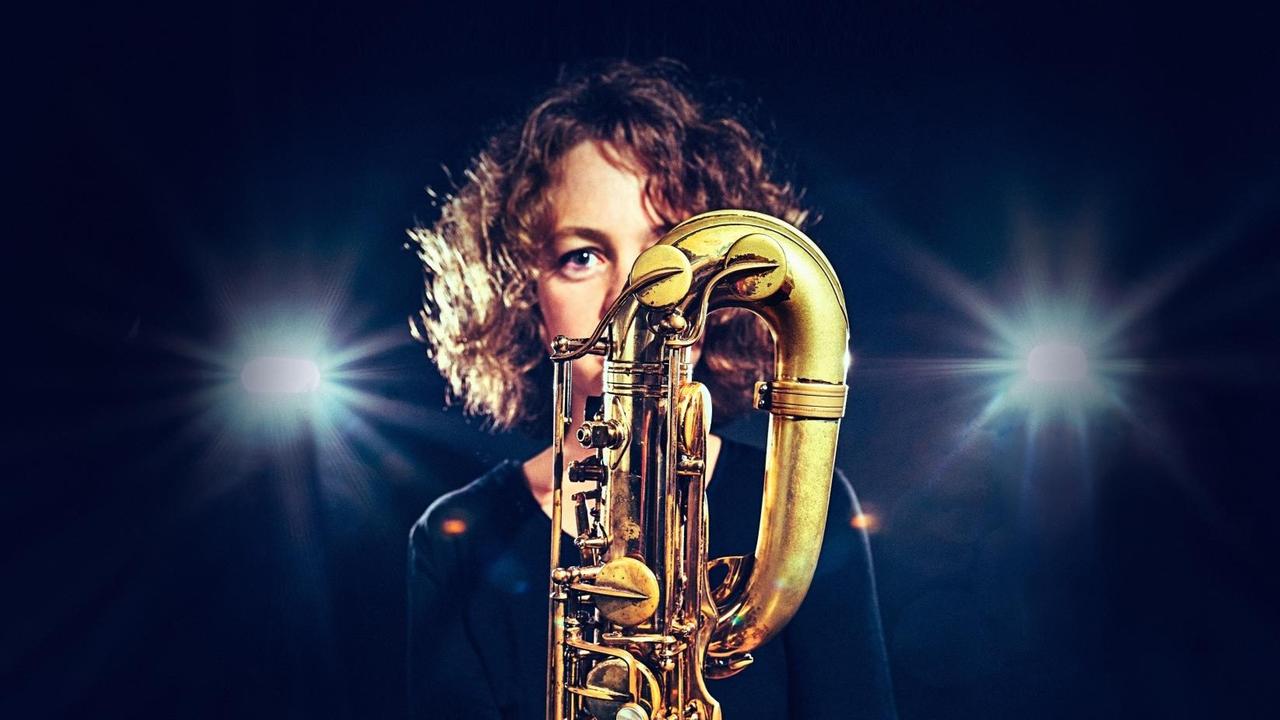 Die Saxofonistin spielt direkt hinter ihrem großen Instrument, das sie fast vollständig überdeckt. Die Saxofonistin spielt direkt hinter ihrem großen Instrument, das sie fast vollständig überdeckt.