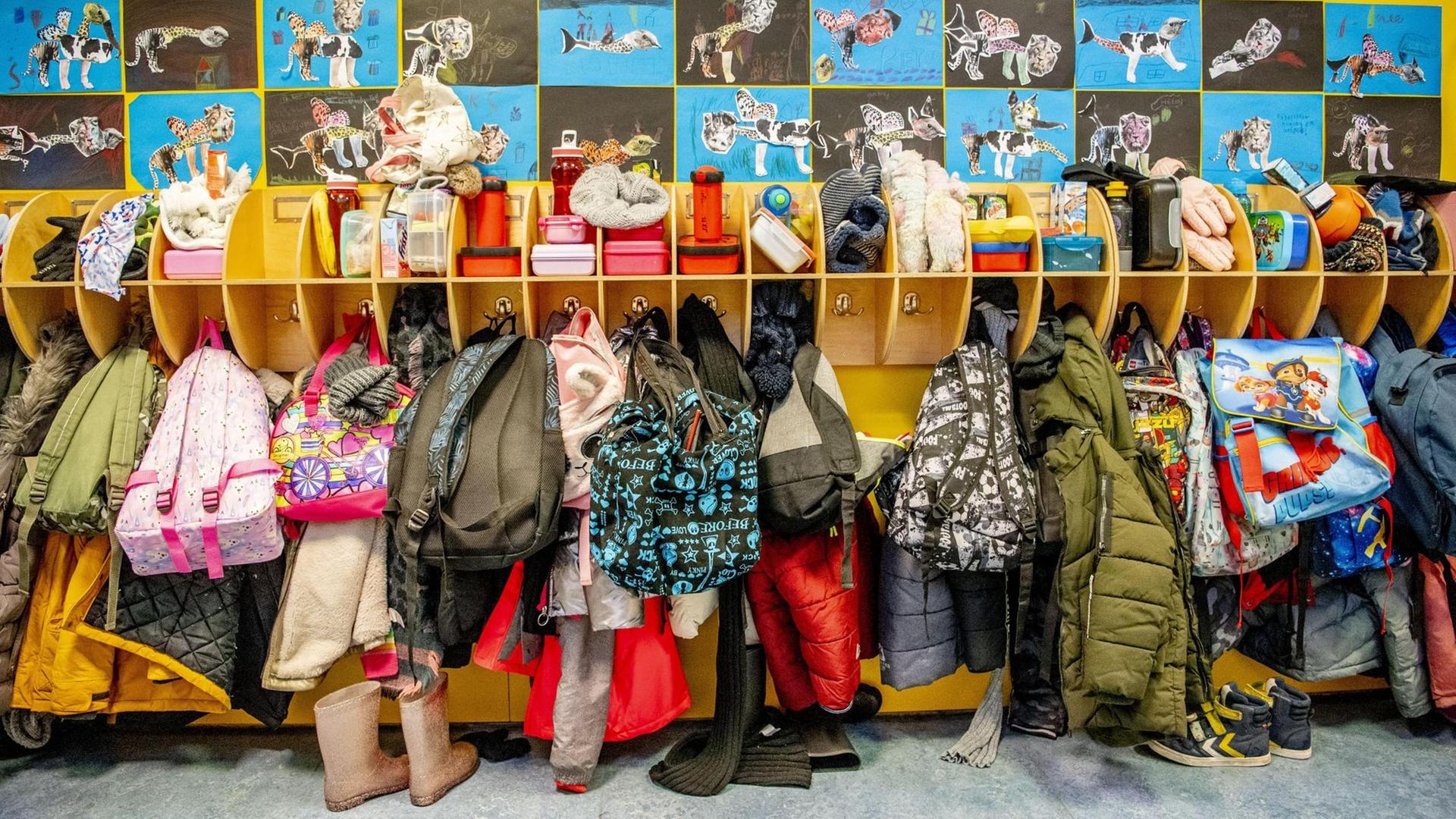 Blick auf eine Schulgarderobe mit vielen Schuhen, Jacken und Mützen. Blick auf eine Schulgarderobe mit vielen Schuhen, Jacken und Mützen.