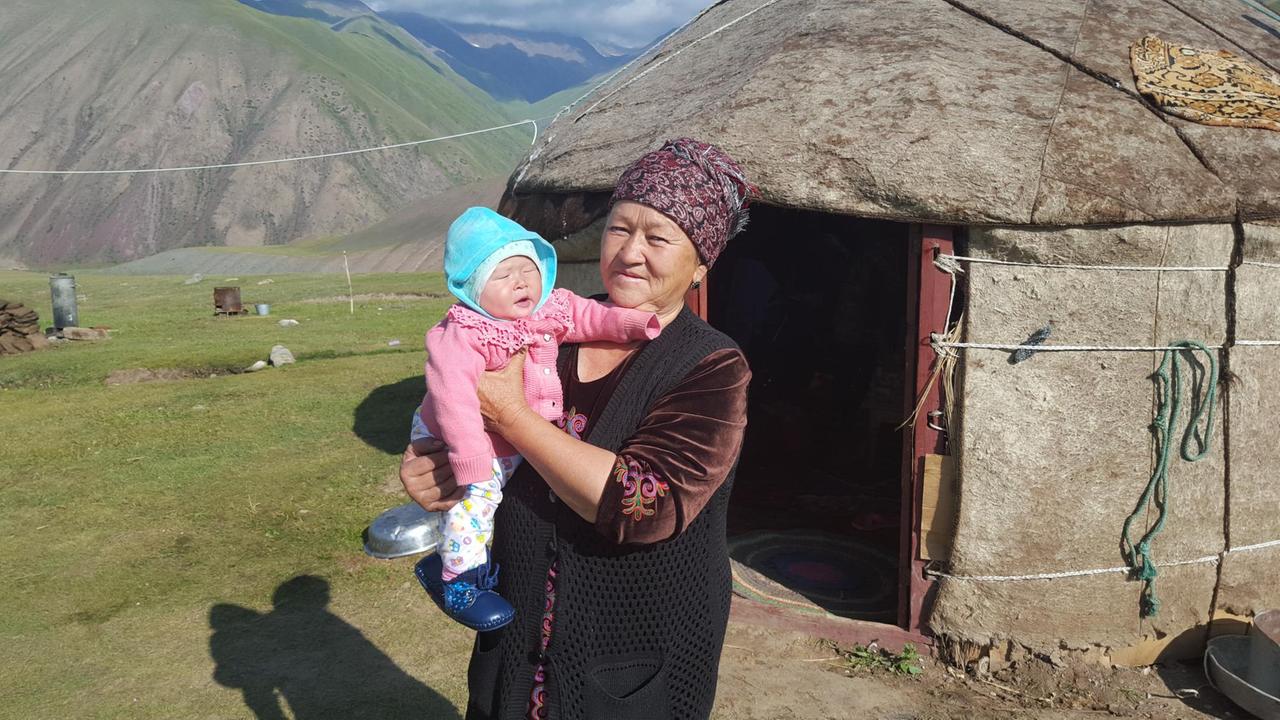 Die Kirgisin Burul Osmanaliyeva mit Enkelkind vor ihrer Jurte.