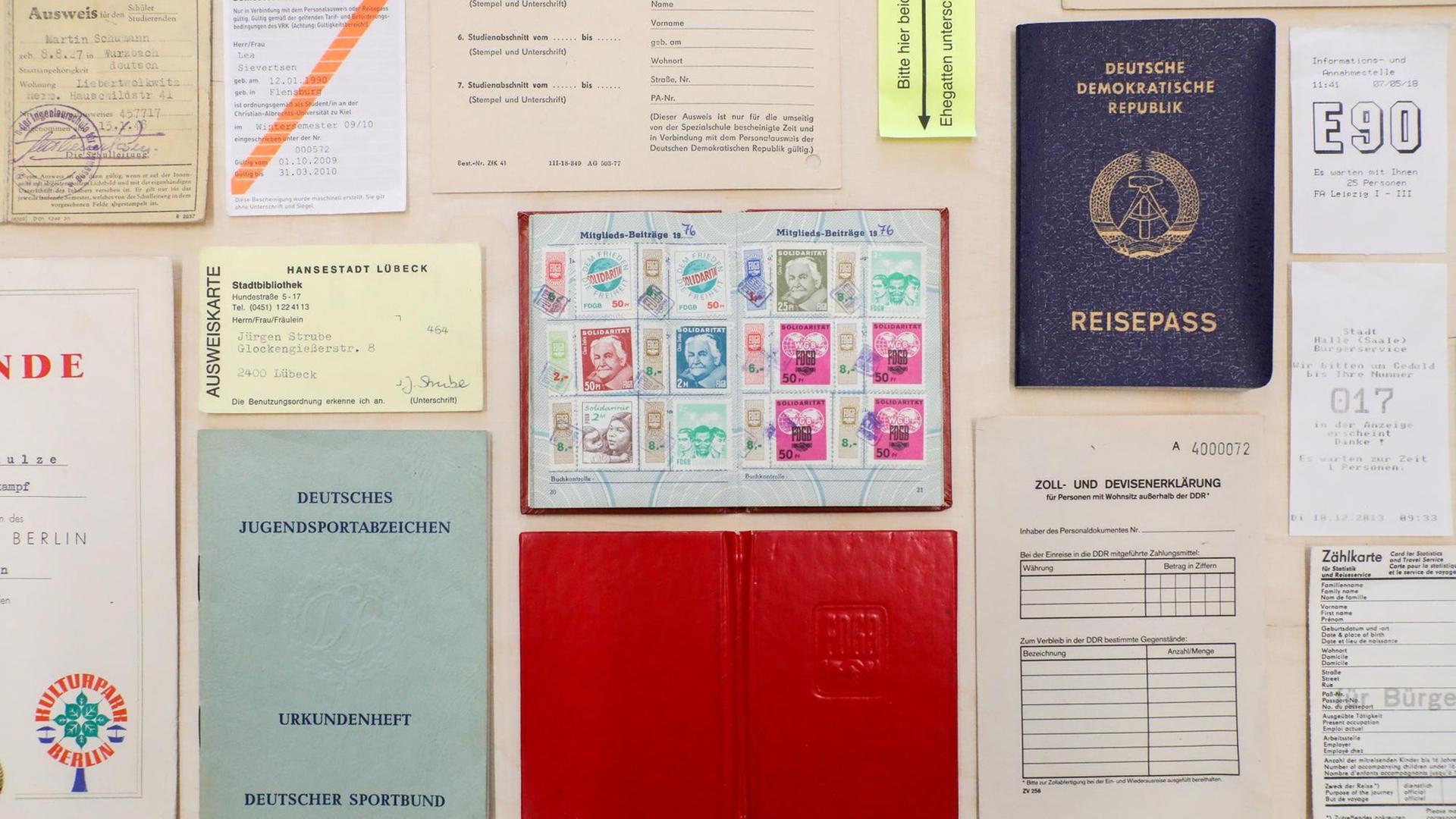 Ein Reisepass und andere Ausweisdokumente der DDR liegen auf einem Ausstellungstisch. Ein Reisepass und andere Ausweisdokumente der DDR liegen auf einem Ausstellungstisch.