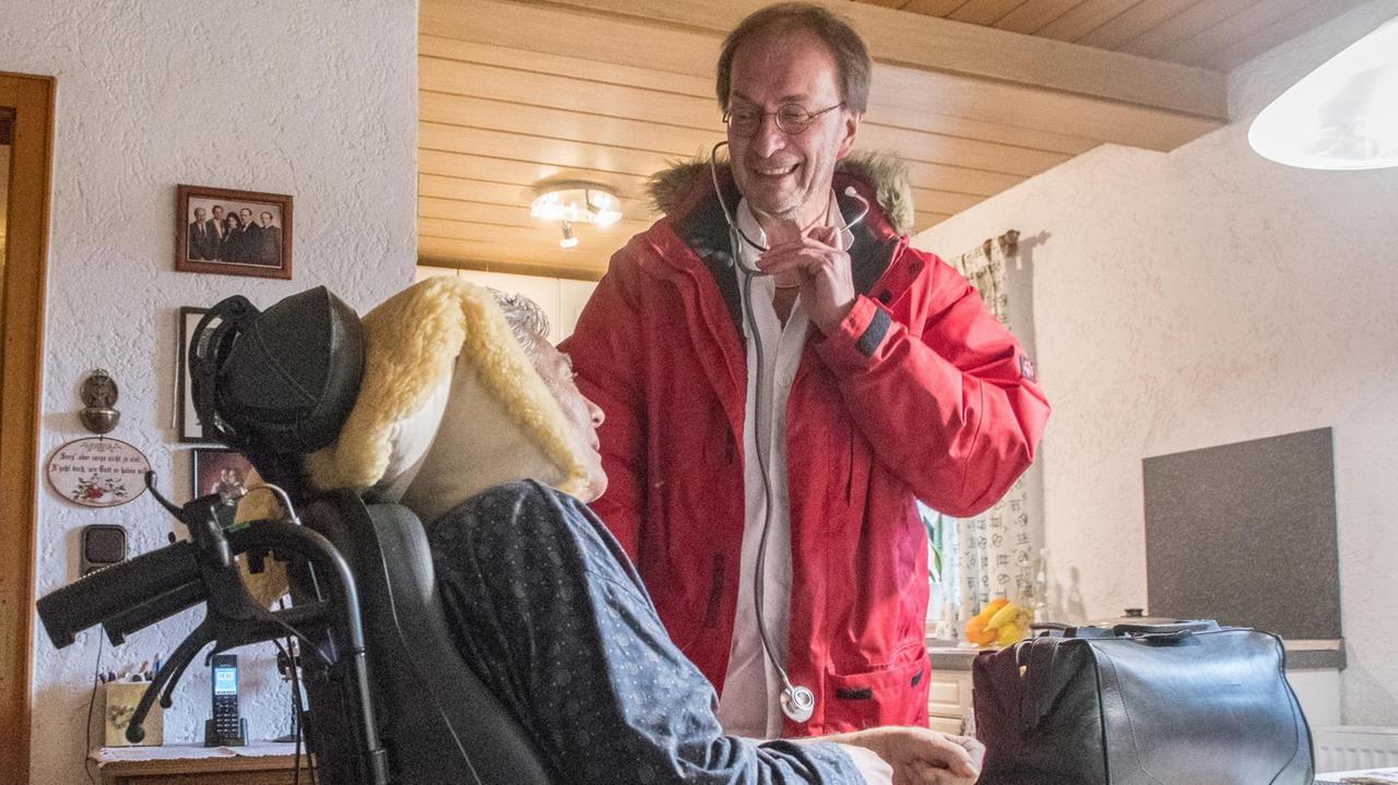 Bayern, Schöllnach: Landarzt Roman Staudinger spricht während einem Hausbesuch mit einem Patienten.