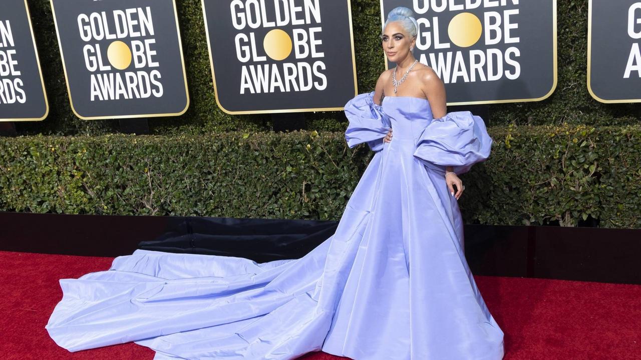 Lady Gaga bei der 76. Verleihung der Golden Globe Awards in Beverly Hills posiert in einem hell-blauen, langen Kleid, das sich über den roten Teppich zieht. 