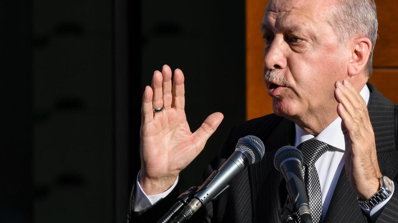 Recep Tayyip Erdogan spricht bei der Eröffnung der DITIB-Zentralmoschee. Er hebt die Hände.
