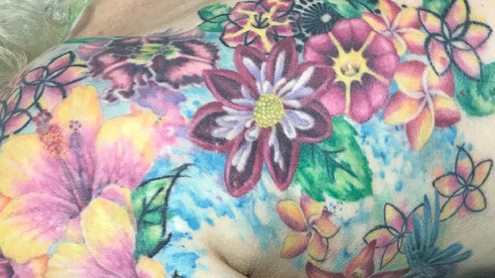 Eine Frau hat sich nach einer Brustkrebs-Operation ein Blumen-Tattoo auf ihrem Oberkörper stechen lassen. Eine Frau hat sich nach einer Brustkrebs-Operation ein Blumen-Tattoo auf ihrem Oberkörper stechen lassen.