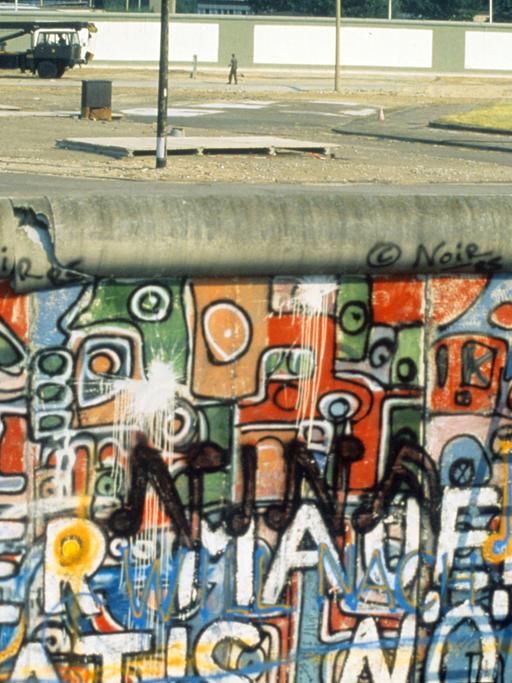 Zeitgeschichte gebannt in einer Fotografie: 1986 demonstriert der Amerikaner John Runnings (r.) mit einem Vorschlaghammer gegen die Berliner Mauer.