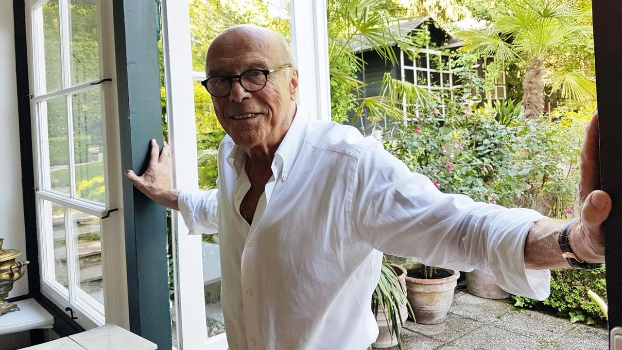 Michael Heltau steht im Türrahmen eines Gartenhauses 