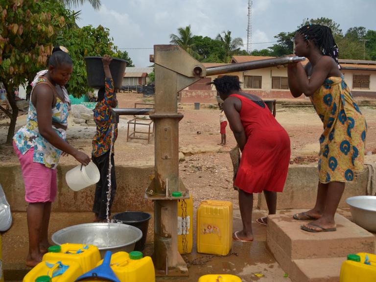 Frauen pumpen Wasser im ghanaischen Dorf Bonsaado