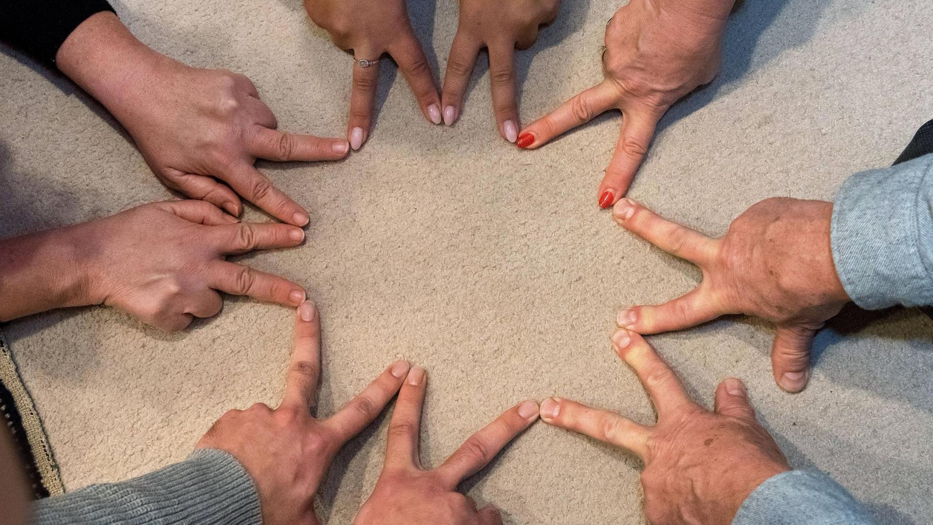 Die Teilnehmer einer Andachtsversammlung der Bahai-Gemeinde in Mainz legen ihre Hände zum Bahai-Symbol zusammen. Die Teilnehmer einer Andachtsversammlung der Bahai-Gemeinde in Mainz legen ihre Hände zum Bahai-Symbol zusammen.
