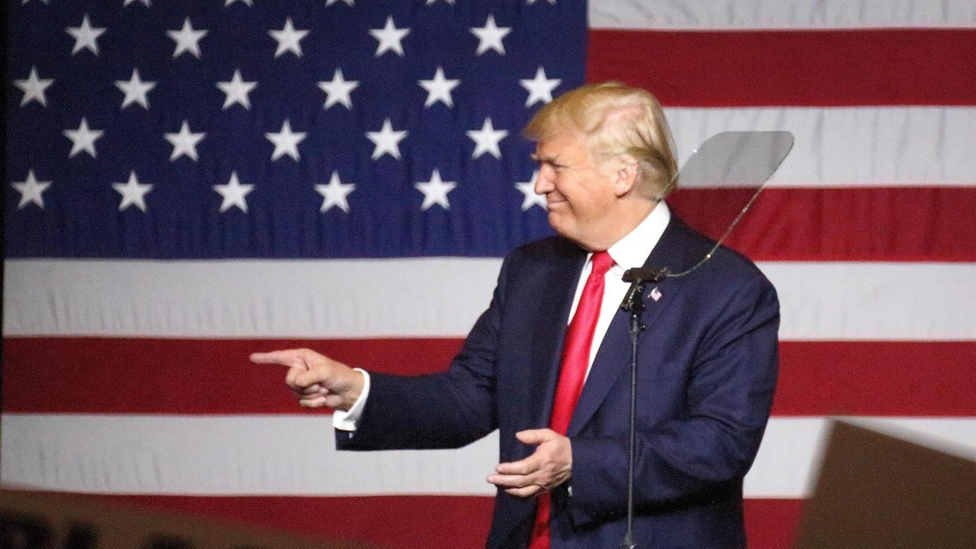 Der republikanische US-Präsidentschaftsbewerber Donald Trump steht während einer Wahlkampfrede im Bundesstaat Florida vor einer großen US-Flagge Der republikanische US-Präsidentschaftsbewerber Donald Trump steht während einer Wahlkampfrede im Bundesstaat Florida vor einer großen US-Flagge
