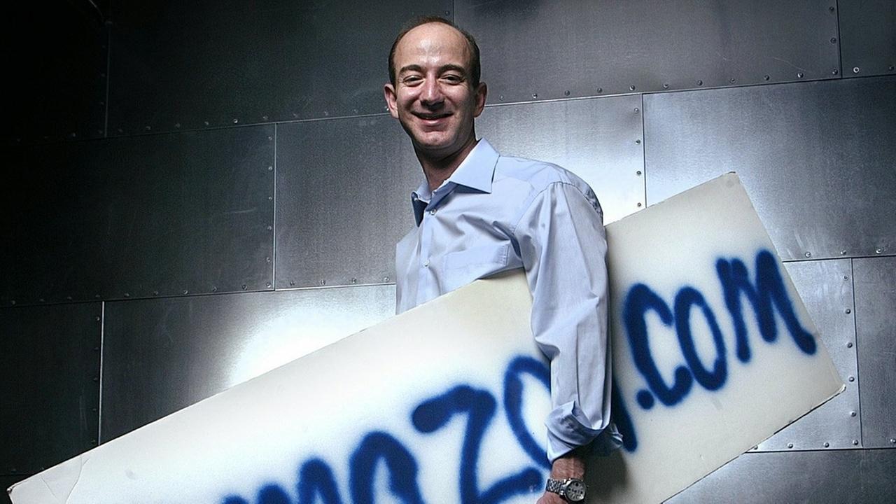 Jeff Bezos 2004 mit dem ersten, von Hand gesprühten Amazon-Firmenschild von 1995 Jeff Bezos 2004 mit dem ersten, von Hand gesprühten Amazon-Firmenschild von 1995