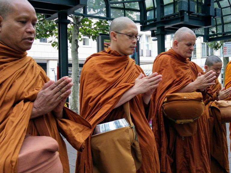 Betende buddhistische Mönche beim Almosengang in Hamburg.