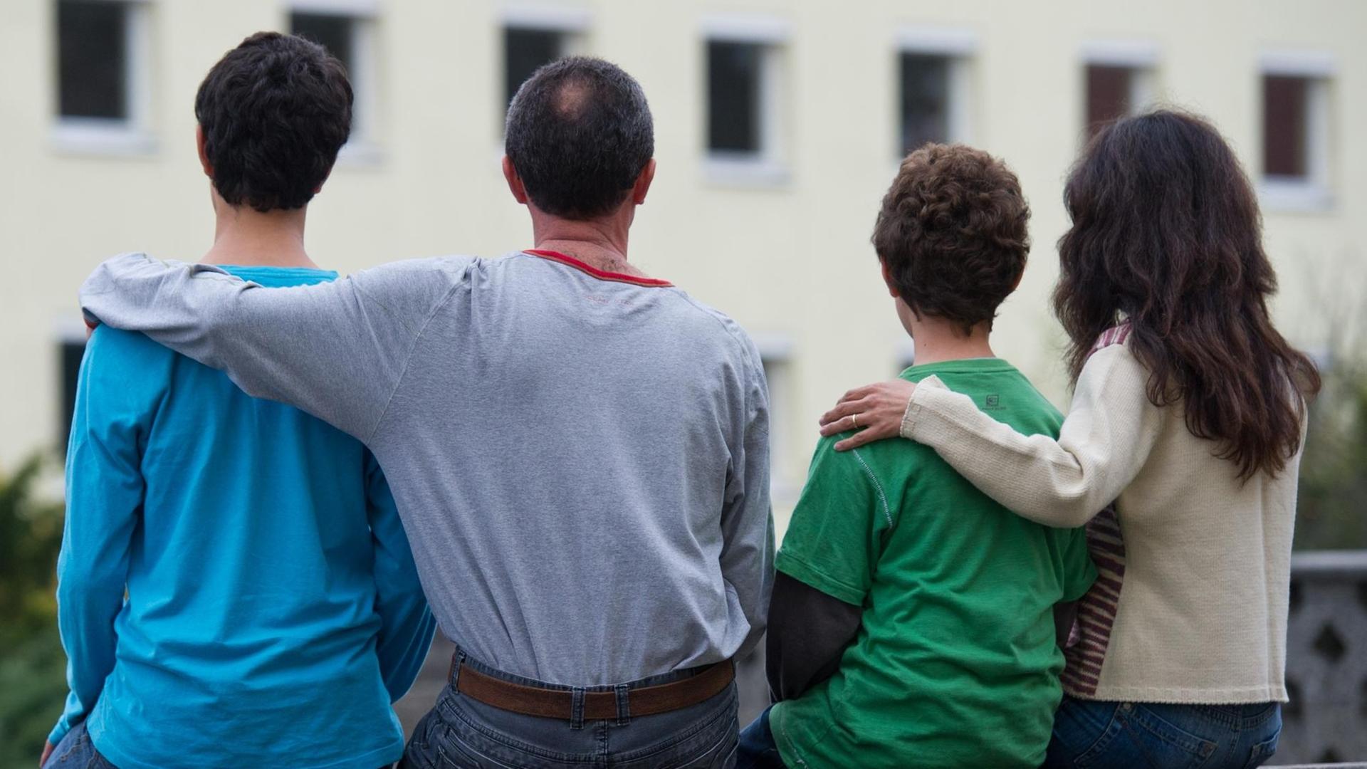 Eine Familie sitzt vor einem Asylwohnheim der Zentralen Ausländerbehörde des Landes Brandenburg in Eisenhüttenstadt. Eine Familie sitzt vor einem Asylwohnheim der Zentralen Ausländerbehörde des Landes Brandenburg in Eisenhüttenstadt.