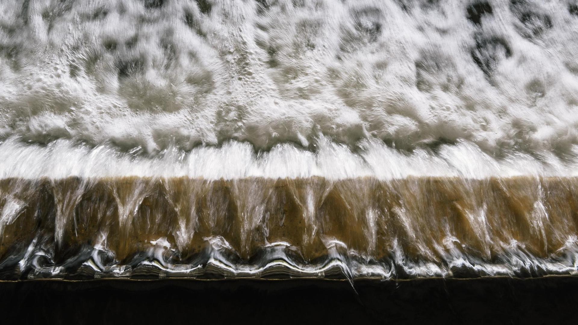 Gereinigtes Wasser strömt in das Filtrationsbecken eines Klärwerks Gereinigtes Wasser strömt in das Filtrationsbecken eines Klärwerks