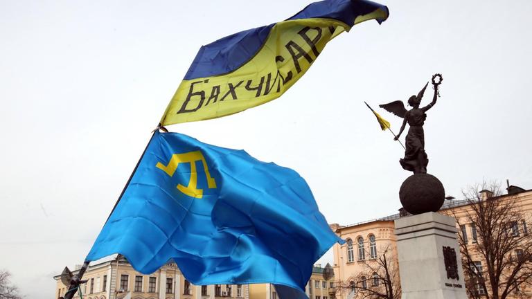 Die Natioanl-Flagge der Krimtataren und die Flagge der Ukraine sind während einer Mahnwache eines Aktivisten der Nationalen Bewegung der Krimtataren Siervier Abibulaiev am 26. Februar 2020 in Charkiw/Nordost-Ukraine zu sehen.