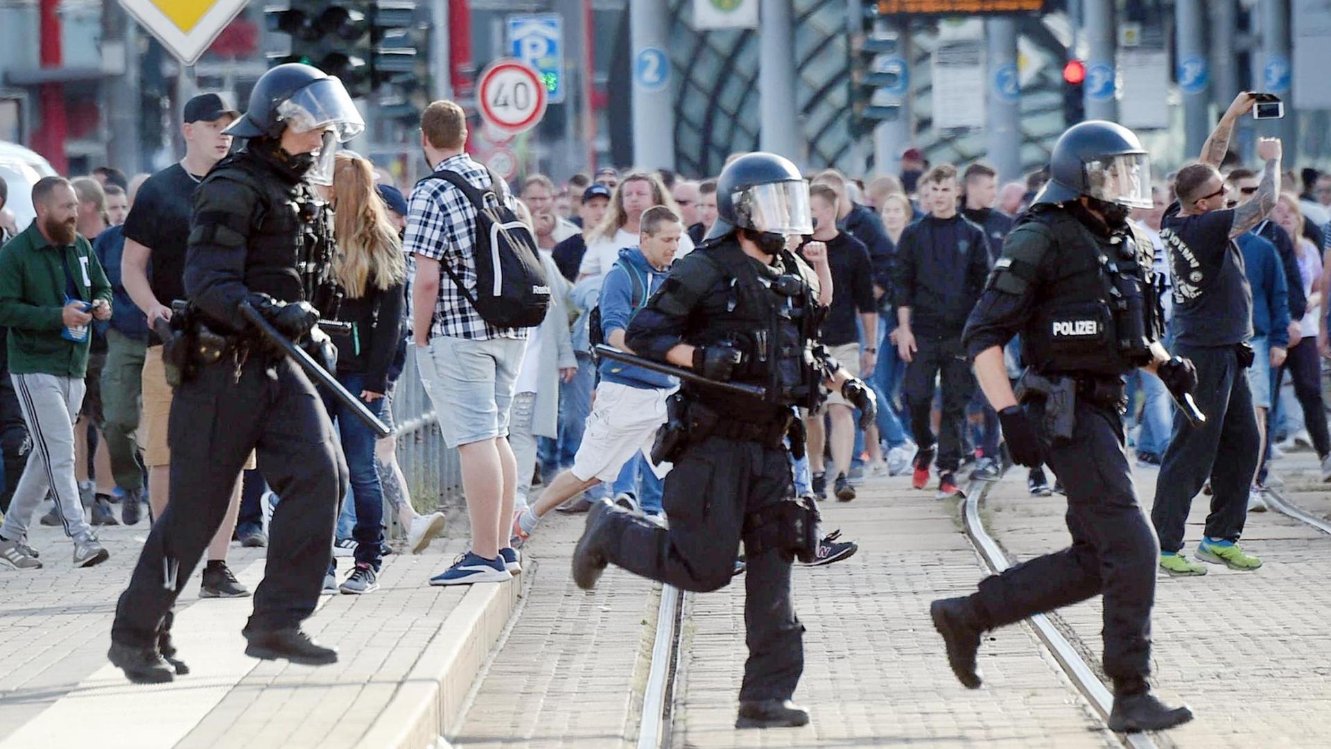 Polizisten laufen nach dem Abbruch des Stadtfestes Chemnitz über eine Straße. Polizisten laufen nach dem Abbruch des Stadtfestes Chemnitz über eine Straße.