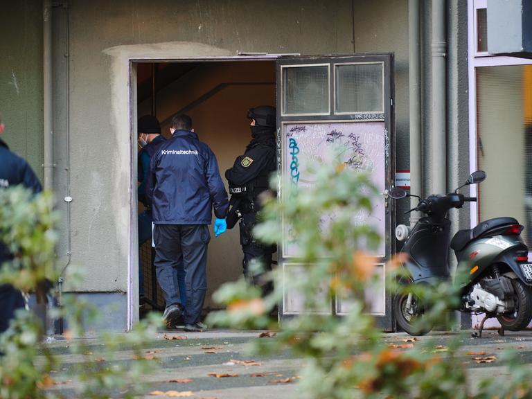 Polizei und Kriminaltechniker stehen bei einem Einsatz in einem Hauseingang. Knapp ein Jahr nach dem Kunstdiebstahl im Dresdner Grünen Gewölbe hat die Polizei am Dienstagmorgen in Berlin drei Tatverdächtige festgenommen. Seit dem Morgen wurden insgesamt 18 Objekte durchsucht.