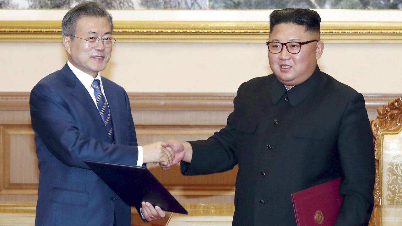 Der nordkoreanische Führer Kim Jong Un (r) und Südkoreas Präsident Moon Jae In schütteln sich die Hände.