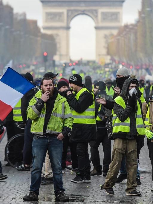 Hunderte Demonstranten mit gelben Westen auf der Straße. Im Hintergrund ist der Triumphbogen zu sehen.