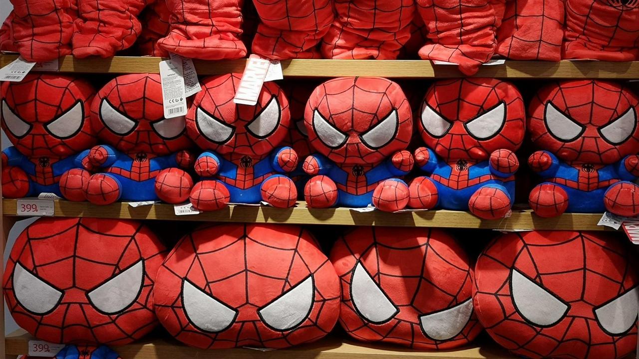 Superhelden von Marvel, Spider-Man Kuscheltiere und Hüte stehen dicht gedrängt in einem Regal. Superhelden von Marvel, Spider-Man Kuscheltiere und Hüte stehen dicht gedrängt in einem Regal.