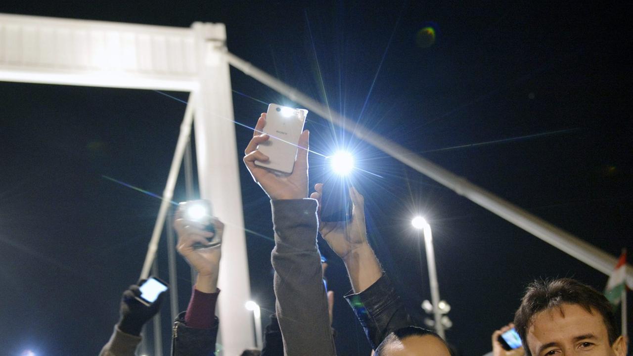 Menschen in Budapest protestieren mit ihren Smartphones gegen die geplante Internet-Steuer. Menschen in Budapest protestieren mit ihren Smartphones gegen die geplante Internet-Steuer.