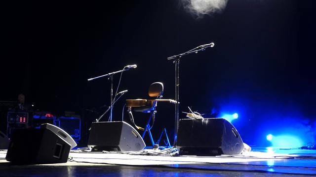 Eine leere Bühne mit Mikrofonen und Gitarre