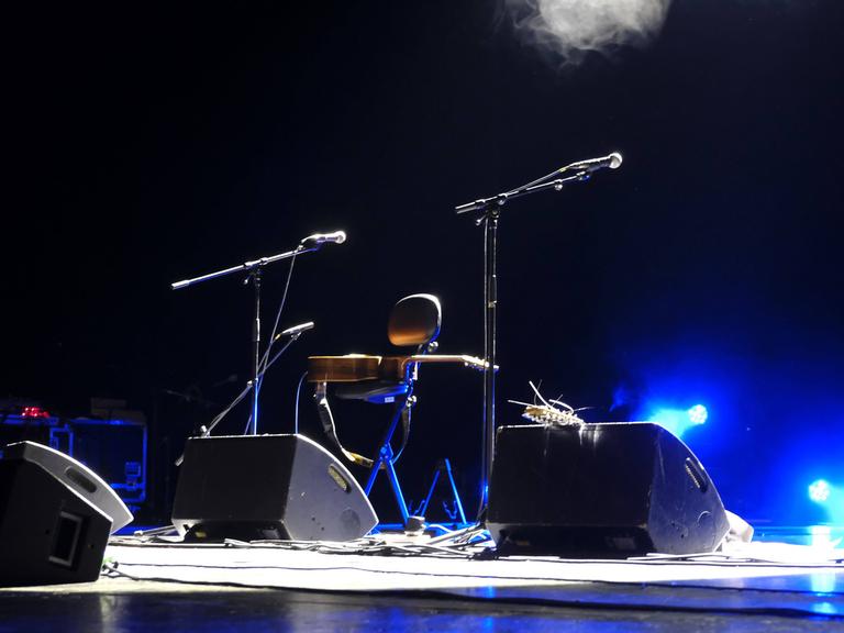 Eine leere Bühne mit Mikrofonen und Gitarre