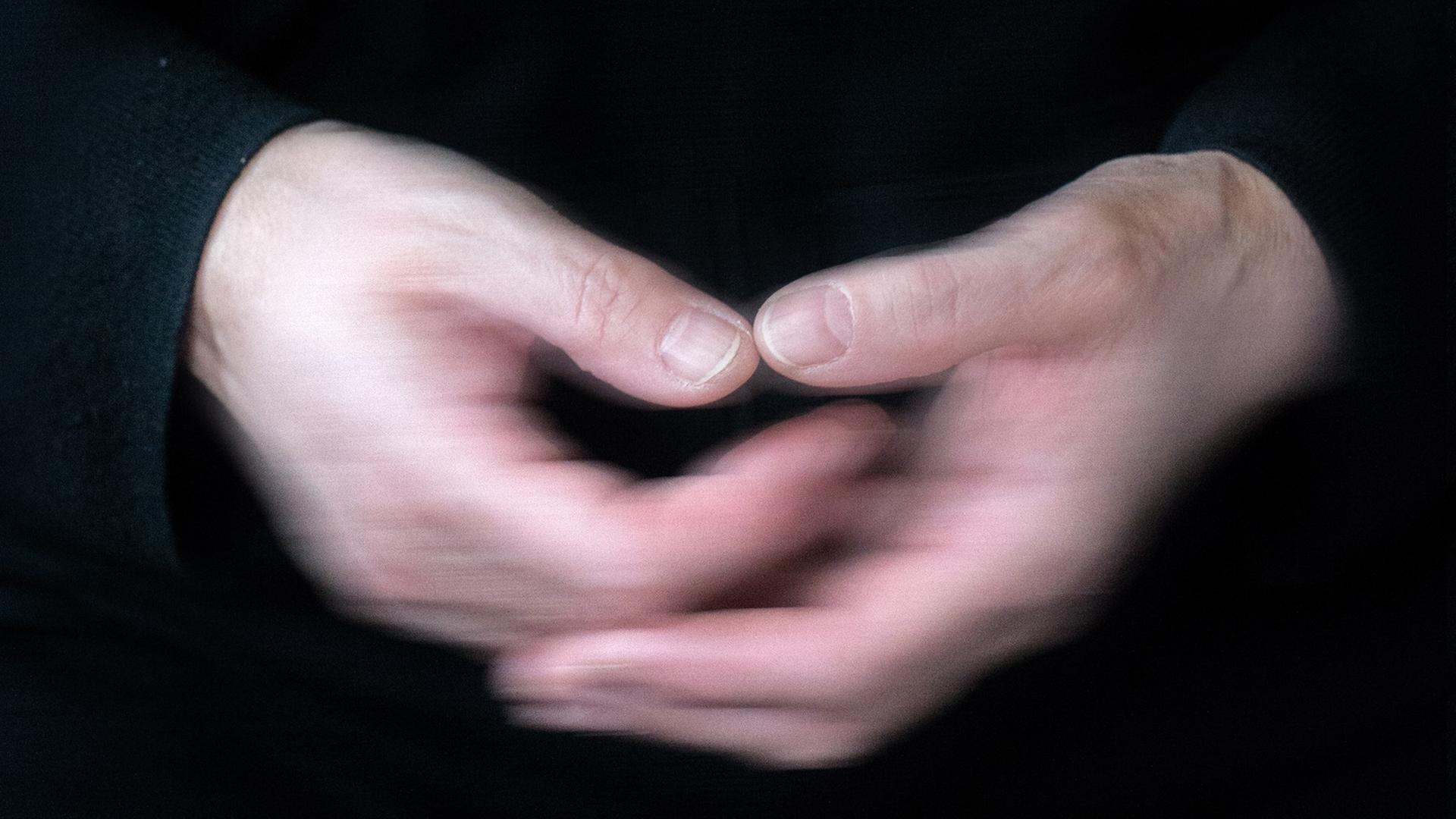 Zwei zitternde Hände berühren sich. Zwei zitternde Hände berühren sich.