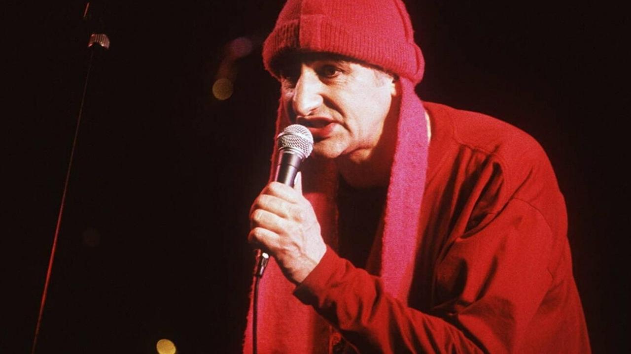 Georg Ringsgwandl in knallig-roter Kostümierung bei einem Konzert.