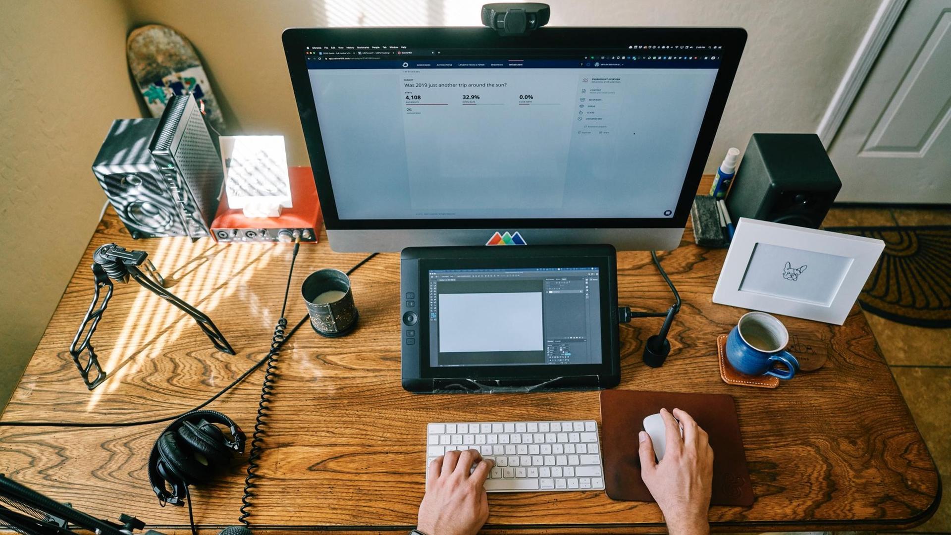 Hölzerner Tisch mit eine Tastatur und zwei Bildschirmen Hölzerner Tisch mit eine Tastatur und zwei Bildschirmen