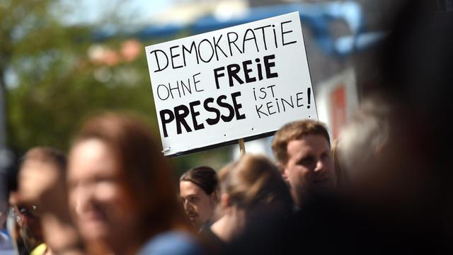 Eine Teilnehmerin einer Demonstration von Unterstützern des Internetportals Netzpolitik.org hält am 1. August 2015 in Berlin bei der Demonstration ein Schild "Demokratie ohne freie Presse ist keine!" in der Hand.