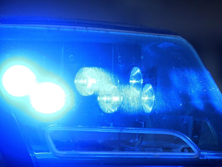Blaulicht eines Polizeiautos, das von einer Pkw-Fensterscheibe reflektiert wird