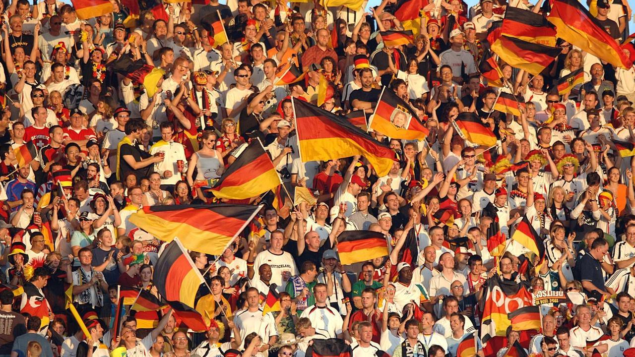 Fußball-Fans schwenken deutsche Flaggen. Fußball-Fans schwenken deutsche Flaggen.