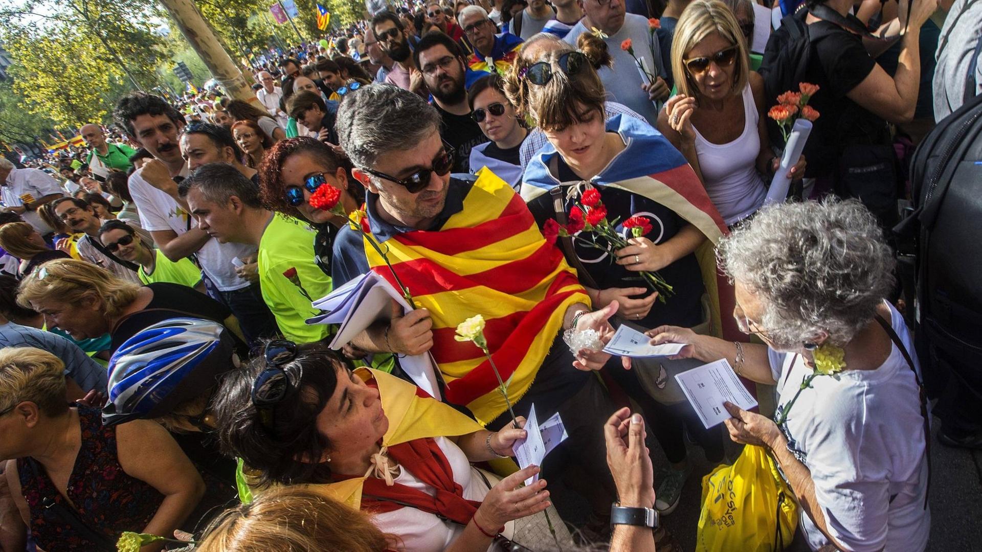 Ein Mann verteilt am 23.09.2017 auf einem Protestmarsch in Barcelona Flugblätter zur Unterstützung des Unabhängigkeitsreferendums für Katalonien. Ein Mann verteilt am 23.09.2017 auf einem Protestmarsch in Barcelona Flugblätter zur Unterstützung des Unabhängigkeitsreferendums für Katalonien.