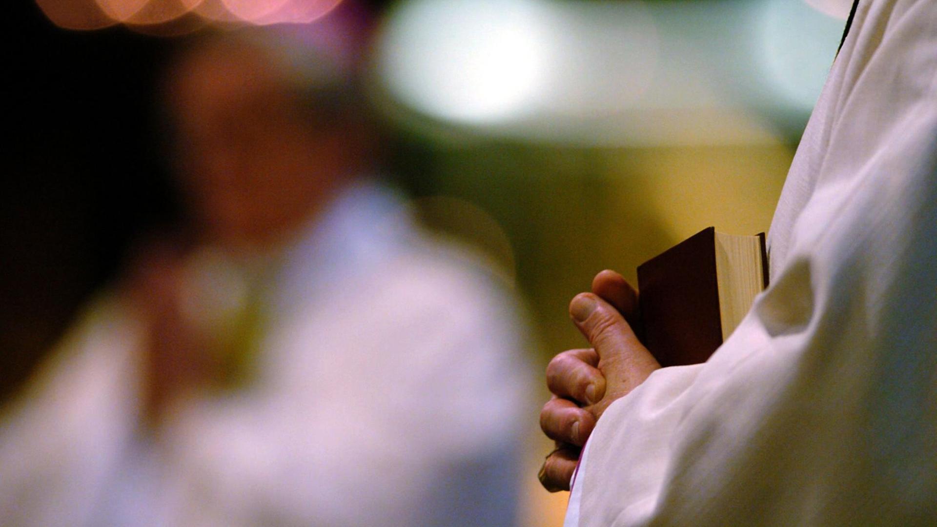 Bischöfe und Priester sitzen mit Gesangbüchern und Bibeln in der Hand im Kölner Dom. Bischöfe und Priester sitzen mit Gesangbüchern und Bibeln in der Hand im Kölner Dom.