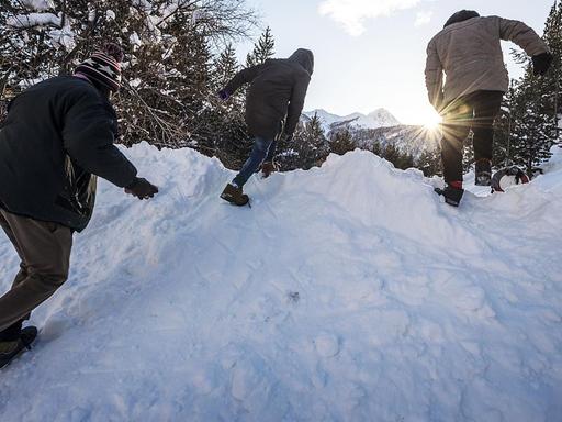 Männer klettern über einen Schneeberg