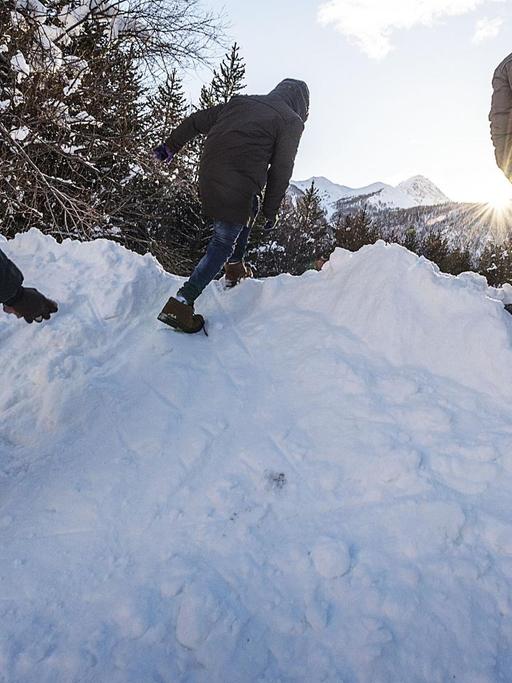 Männer klettern über einen Schneeberg