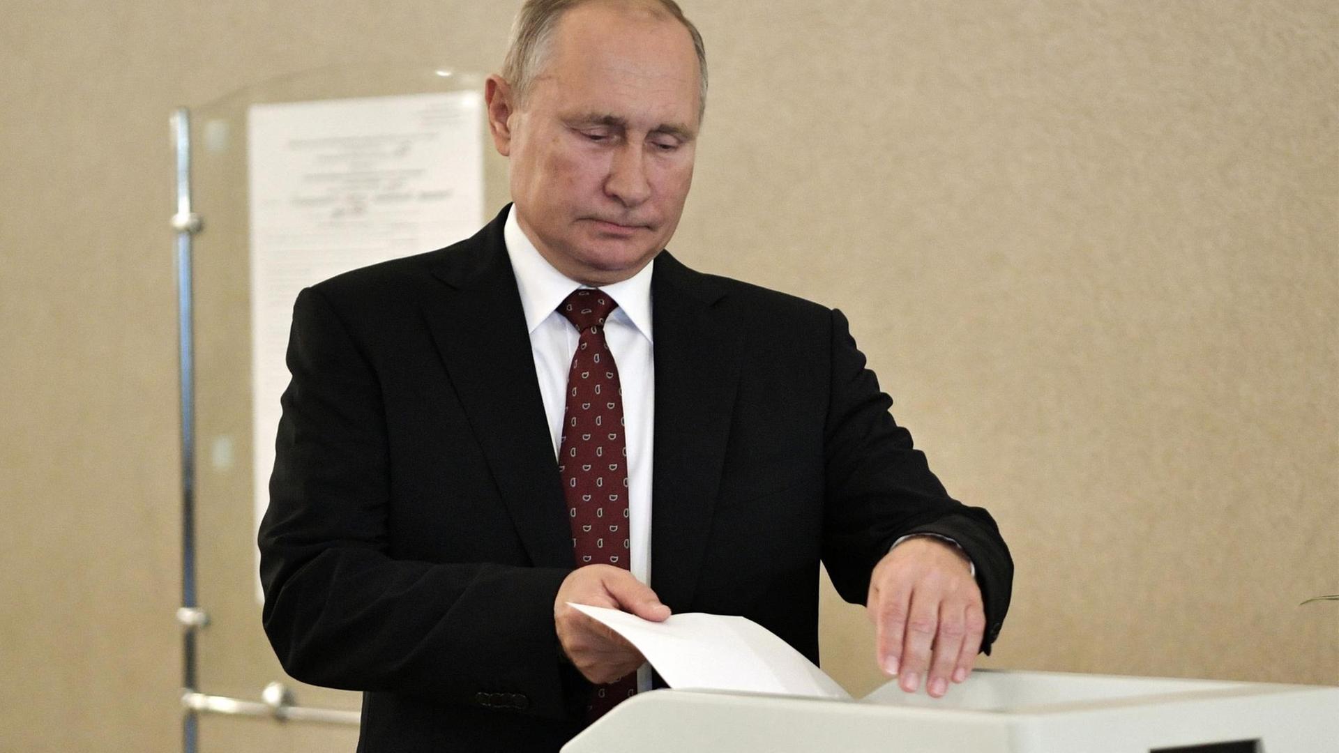 Der russische Präsident Putin wirft seinen Wahlzettel in die Urne. Der russische Präsident Putin wirft seinen Wahlzettel in die Urne.