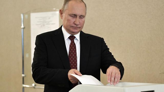 Der russische Präsident Putin wirft seinen Wahlzettel in die Urne.