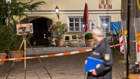 Ein Polizist arbeitet in Ansbach am Tatort.