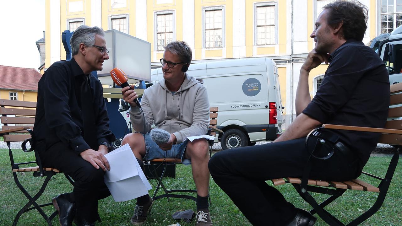 Oliver Weder (links) und Sven Helbig (rechts) im Gespräch mit Deutschlandfunk Kultur-Redakteur Carsten Beyer.