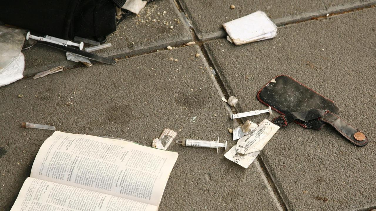 Benutzte Spritzen eines Heroinabhängigen liegen auf dem Bordstein. Benutzte Spritzen eines Heroinabhängigen liegen auf dem Bordstein.