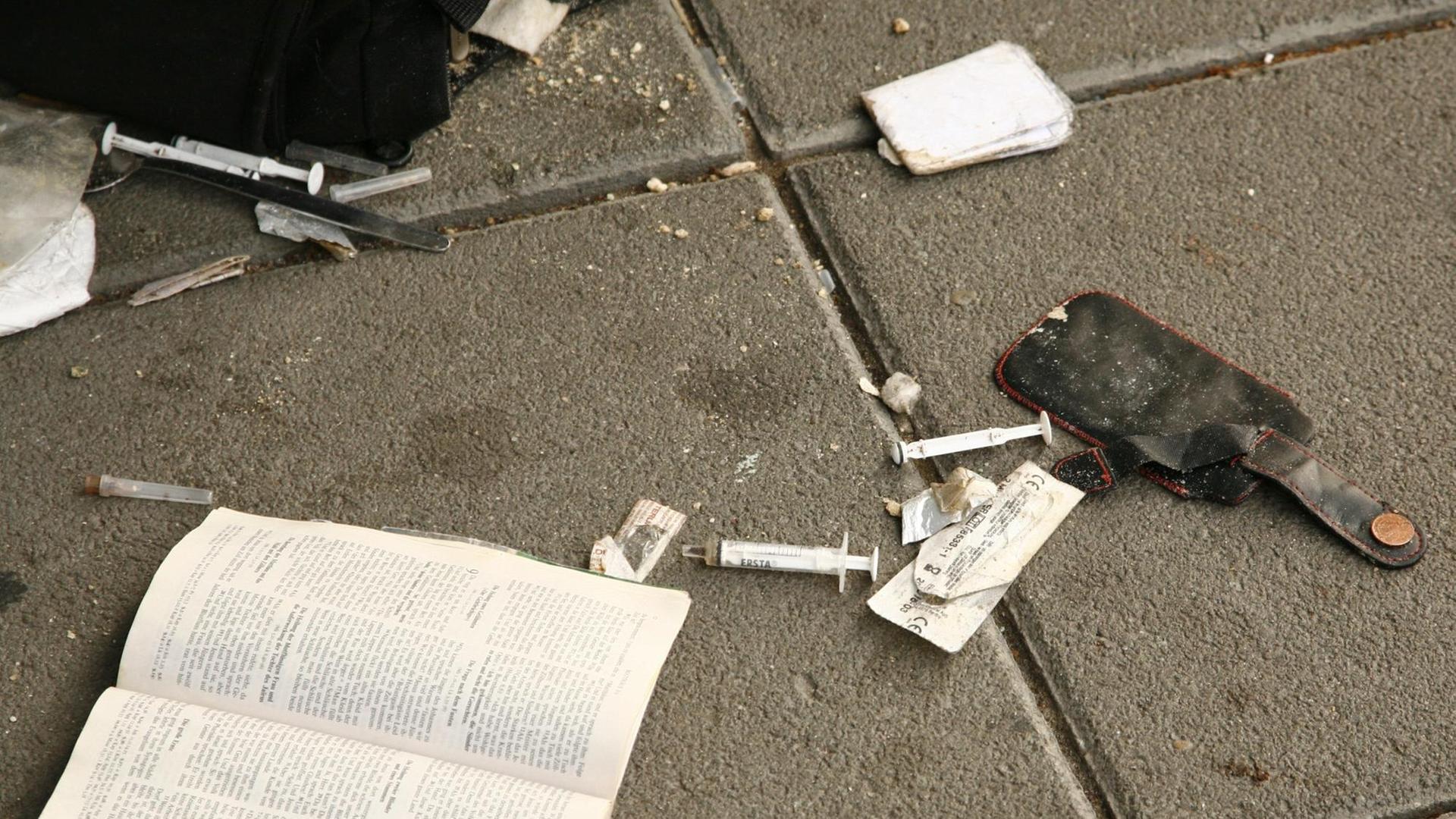 Benutzte Spritzen eines Heroinabhängigen liegen auf dem Bordstein. Benutzte Spritzen eines Heroinabhängigen liegen auf dem Bordstein.
