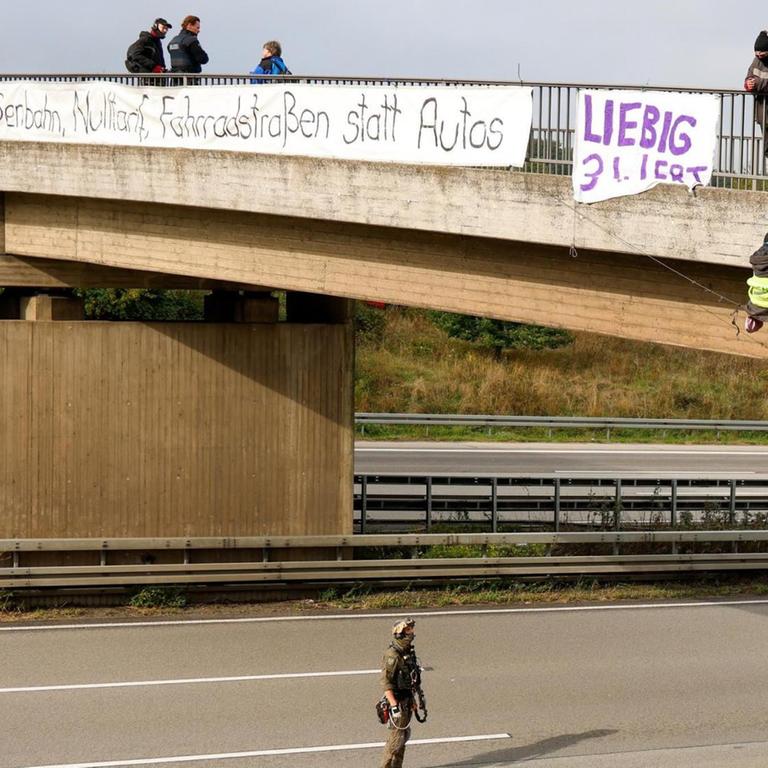 Hessen, Idstein: Umweltaktivisten hängen an einer Brücke über der Autobahn 3 und protestieren gegen die Rodung von Bäumen im Herrenwald und Dannenröder Forst bei Stadtallendorf im Zusammenhang mit dem geplanten Ausbau der Autobahn 49. 